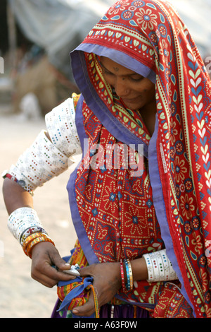 Laboriosa MIR tribeswoman nomadi del Gujarat,indossare gioielli tradizionali e luminose vestiti colorati con veli sopra la testa Foto Stock