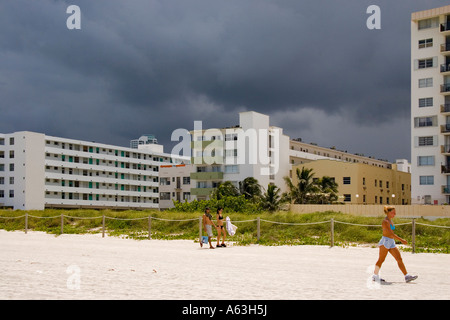 La sabbia bianca sulla spiaggia di Miami Beach è in contrasto con un colore scuro e cielo nuvoloso Foto Stock