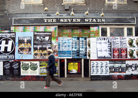 Saliti fino pub coperto di bill poster su Brick Lane, Tower Hamlets, London, England, Regno Unito Foto Stock