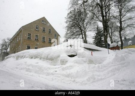 Metri di altezza neve coveres il giardino nella parte anteriore di un appartamento casa a Oberwiesenthal, Monti Metalliferi, Erz Monti Metalliferi, Sassonia Foto Stock