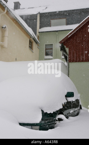Nevicato in auto su una neve parcheggio coperto di fronte un appartamento casa a Oberwiesenthal, Monti Metalliferi, Erz Monti Metalliferi Foto Stock