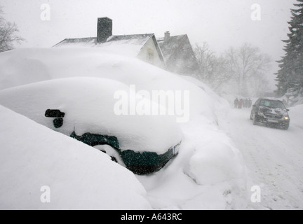 Coperta di neve auto nella parte anteriore di un appartamento casa a Oberwiesenthal, Monti Metalliferi, Erz Monti Metalliferi, Bassa Sassonia, Germania Foto Stock