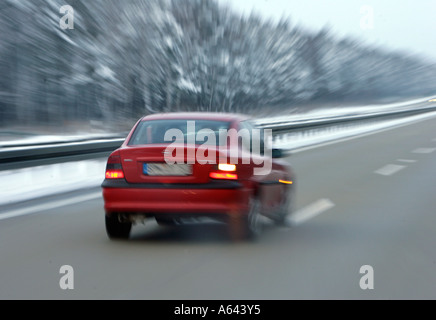 Unità auto molto veloce sul bagnato una autostrada tedesca in inverno Foto Stock