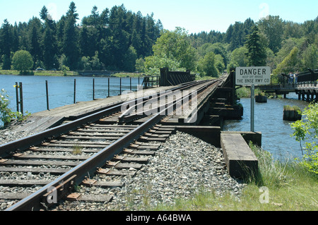 I binari della ferrovia andare oltre il traliccio in distanza intorno a curva Foto Stock