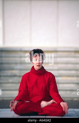 Carol Smith insegnante di Yoga meditazione in piena posizione del loto di fronte al Milton Keynes buddista Pagoda di pace Foto Stock