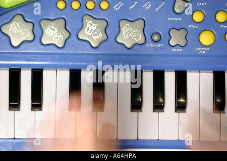 Childs dita giocando un giocattolo tastiera Foto Stock