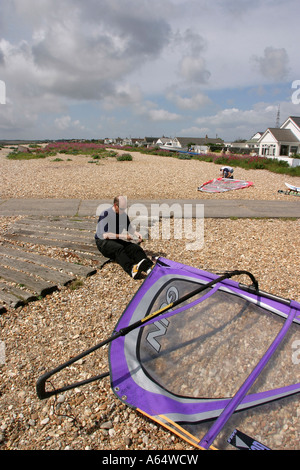 Regno Unito West Sussex Pagham spiaggia windsurf preparazione vicino lungomare case Foto Stock