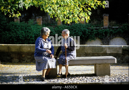 Due donne seduta su una panchina di pietra a Granada, Spagna. Foto Stock