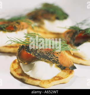 Gravadlax (salmone scandinavo con aneto e spezie) e panna acida su blinis Foto Stock