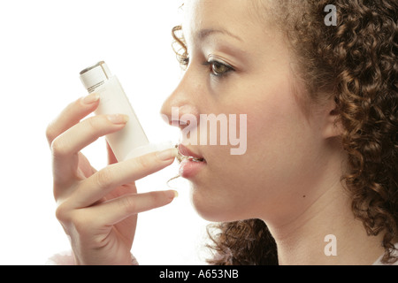 Donna nelle sue venti utilizzando un dilatatore bronchiale a causa di un attacco d' asma. Foto Stock