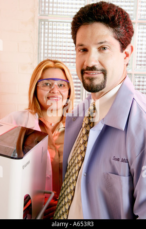 Ritratto di un dentista e igienista o assistente di laboratorio. Estrazione del DNA la macchina è raffigurata come bene. Foto Stock