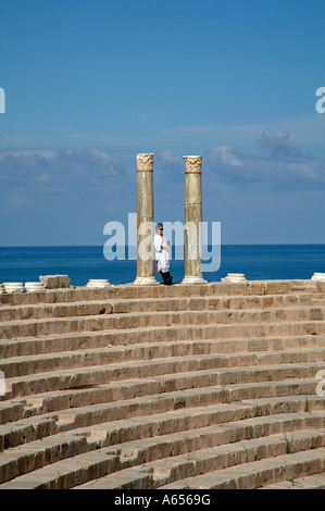 Ammirando la vista dalla sommità della cavea nel teatro di Leptis Magna Libia due colonne di cipollino rimangono del colonnato Foto Stock