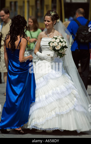 Sposa e damigella parlando su strada Foto Stock