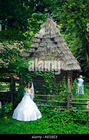 Sposa si fermò davanti a un tradizionale tetto di paglia house presso il museo della musica popolare Architetto e la vita rurale Foto Stock