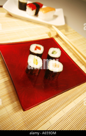 Sushi su una targhetta rossa con i bastoncini Foto Stock