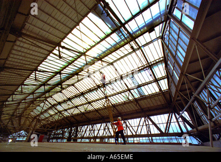 Scaffolders controllare i supporti del tetto del treno di Waterloo Shed costruito nel 1922. Esso copre il 19 piattaforme della stazione. Foto Stock