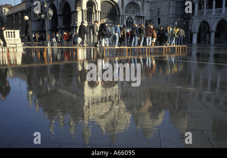 I residenti di Venezia a piedi su sentieri rasied in piazza san marco come la città inondazioni regolarmente Foto Stock