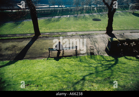 Inizio mattina di primavera nei giardini di Princes Street Edinburgh un solitario visitatore si siede su una panchina nel parco Foto Stock