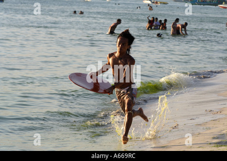 Giovane uomo shore surf sulla spiaggia di Boracay, Isole Filippine Foto Stock