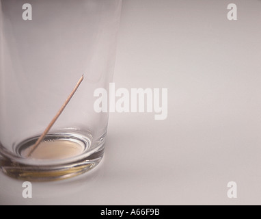 Immagine a colori fuori da un bicchiere vuoto con un cocktail di rotti stick al suo interno Foto Stock