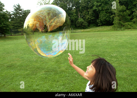 Giocando con le bolle in un parco erboso Maryland Foto Stock