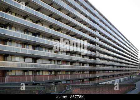 Lungo e alto blocco di abitazioni locali con balcone in comune accesso alle porte d'ingresso di Londra Inghilterra Regno Unito Foto Stock