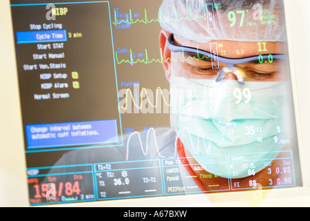 Montaggio del chirurgo e la lettura del monitor dei segni vitali Foto Stock