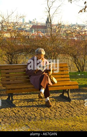 Una donna anziana lettura in Letna Park nel centro di Praga Repubblica Ceca Foto Stock