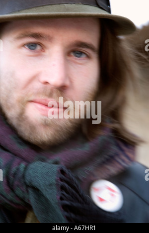 Giovane artista con fedora e lieve smirk percorrendo una strada durante l'inverno in Fredericton, New Brunswick, Canada Foto Stock