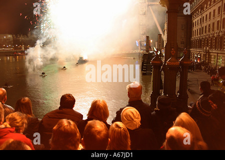 La gente a guardare i fuochi d'artificio da Westminster Bridge di Londra sul capodanno celebrazioni 2004 Foto Stock