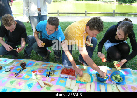 4 adolescenti godendo picnic nel parco di Bois de Boulogne durante schooltrip a Parigi Francia Foto Stock