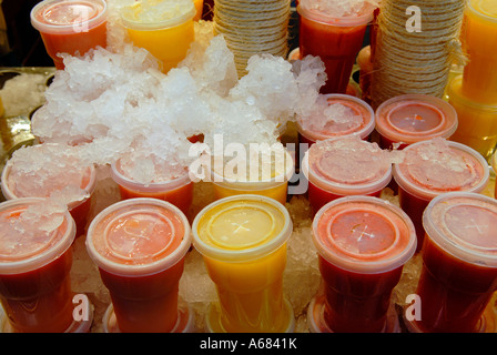 Cocktail freschi con succo di frutta freddo in tazze di plastica usa e getta a Mercat de Sant Josep de la Boqueria nel quartiere Ciutat Vella di Barcellona, Spagna Foto Stock