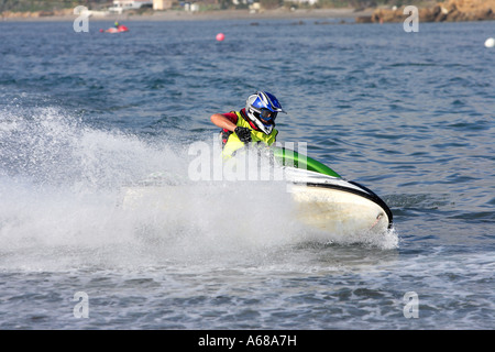 Giovane uomo accelerando lungo su una piccola jetbike o jetski durante una gara sul mare o sull'oceano Foto Stock