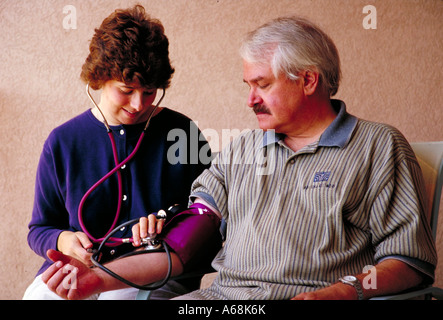 La somministrazione di infermiere del test della pressione del sangue uomo Foto Stock