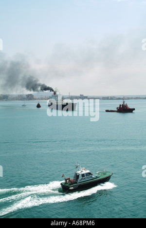 Nave cargo che si sminuisce il fumo nero e le emissioni di fuliggine provenienti da imbuto che inquinano l'atmosfera locale e l'ambiente in arrivo al porto di Palma Mallorca Spagna Foto Stock