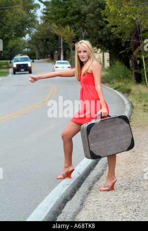 Giovane ragazza di runaway autostop sulla carreggiata Foto Stock