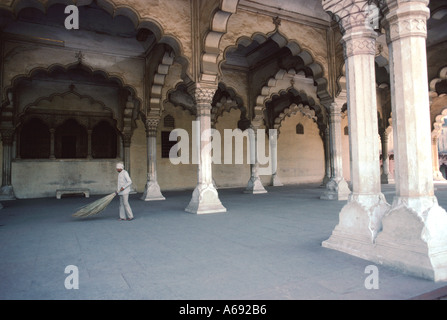 Agra Fort Uttar Pradesh. Un lavoratore con attenzione spazza il pavimento della sala delle udienze pubbliche Diwan i Aam Hall Foto Stock