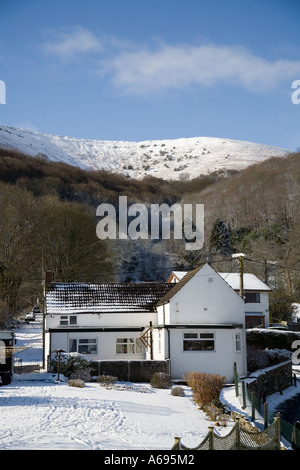 Case residenziali a Llanfoist villaggio nei pressi di Abergavenny con la montagna Blorenge in inverno Wales UK e fusione della neve sul tetto Foto Stock