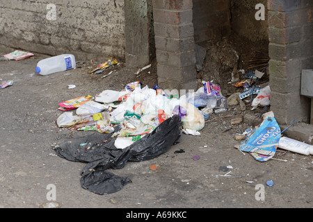 Rotto sacco della spazzatura con contenuti sparse in un vicolo Foto Stock