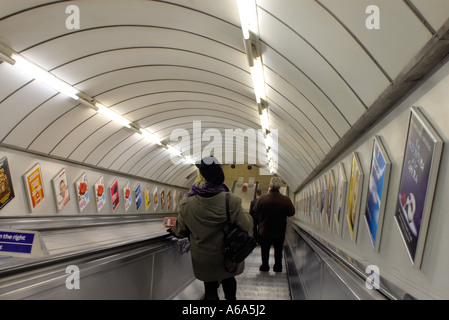 La gente di escalator in discesa nella stazione della metropolitana di Londra Foto Stock