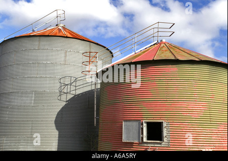 Coppia di grano vecchio silo di asciugatura s contro un blu cielo nuvoloso Foto Stock
