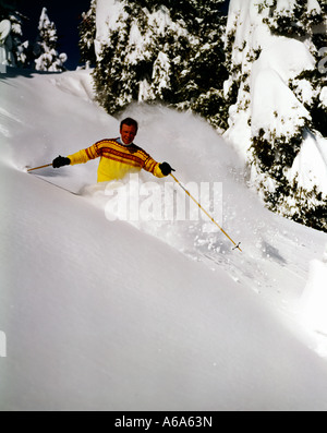 Sciatore si immerge in discesa attraverso il torace profondo Neve fresca Foto Stock