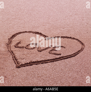 Valentino amore simbolo disegnato nella sabbia in spiaggia Foto Stock