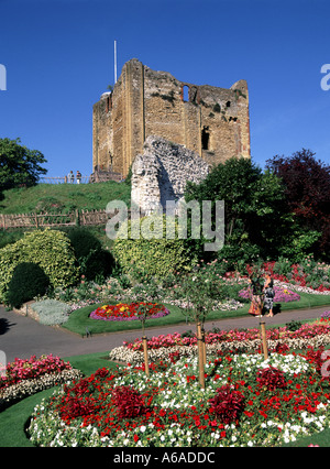 Rovine del castello di Guildford oltre i sentieri attraverso il parco pubblico formale esposizione floreale estiva di colorate piante da letto cielo blu giornata di sole Surrey Inghilterra Regno Unito Foto Stock