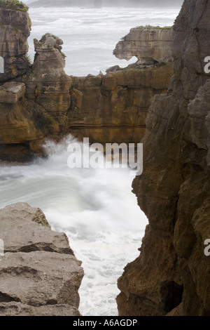 Onde che si infrangono contro le rocce calcaree, presso il Pancake Rocks, Nuova Zelanda Foto Stock