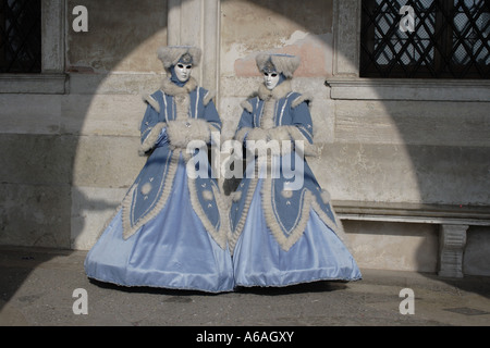 Maschere seduta sul banco di prova all'ombra di portici su Piazza San Marco a Venezia Carnevale,sito Patrimonio Mondiale dell'UNESCO, l'Italia, l'Europa. Foto di Matheisl Foto Stock