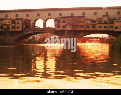 Il Ponte Vecchio sulla riva del fiume Arno a Firenze al tramonto Foto Stock
