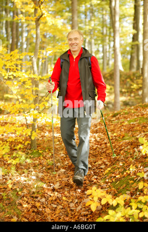 Senior uomo nordic walking nella foresta di autunno Foto Stock