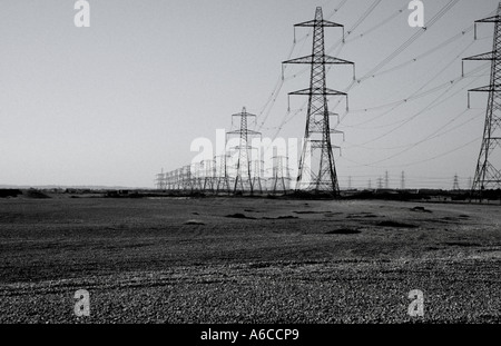 Le linee di alimentazione che conduce lontano da Dungeness Nuclear Power Station Foto Stock