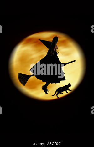 Cinque anni ragazza dissimulata come un flying strega per Halloween Foto Stock